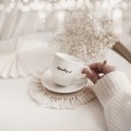 Biała filiżanka porcelanowa do espresso ze spodkiem 100 ml - napis uśmiechnij się ze złotym sercem dla przyjaciółki na urodziny Filiżanka porcelanowa ze złotym sercem espresso ze spodkiem - Uśmiechnij się! nadzwyczajnie.mom — widok z boku na białym tle