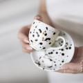 Biała filiżanka porcelanowa 100 ml do espresso ze spodkiem - ręcznie malowany motyw czarnych kropek zdobiony złotem dla miłośniczki kawy na urodziny Zbliżenie na złote zdobienie na białym filiżance porcelanowej Ręcznie malowana espresso ze spodkiem - Czarne kropki
