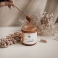 Złocisty miód z rokitnikiem 200 g - owocowy smak dla bliskiej osoby na święta Biały produkt porcelanowy nadzwyczajnie.mom ze złotym zdobieniem i napisem Miód z rokitnikiem - 200 g