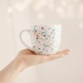 Biały kubek porcelanowy 300 ml - motyw nakrapiany błękitem i złotem dla niego na urodziny Biały kubek porcelanowy nadzwyczajnie.mom ze złotym zdobieniem i napisem Nakrapiany błękitem i złotem — 300 ml