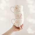 Biały kubek porcelanowy 300 ml - motyw nakrapiany różem i złotem dla niej na urodziny Kubek porcelanowy ze złotym zdobieniem Nakrapiany różem i złotem nadzwyczajnie.mom — widok z boku na białym tle