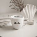 Biały Kubek Porcelanowy 300 ml - Napis Dzień Dobry Skarbie ze Złotym Sercem dla Ukochanej Osoby na Rocznicę Zbliżenie na złote zdobienie serca na białym kubku porcelanowym Biały Kubek Porcelanowy 300 ml - Napis Dzień Dobry