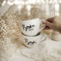 Zestaw 2 białych kubków porcelanowych 500 ml - motyw złotego serca i napisów boski mąż boska żona dla małżonków na ślub Zbliżenie na złote zdobienie serca na białym zestawie porcelanowym kubków 500 ml - Boski Mąż Boska Żona nadzwyczajnie.mom